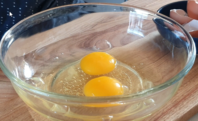 Whisking eggs and setting up bread crumbs for Korean corn dogs