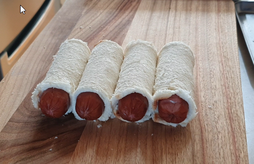 Rolling sausage with flattened bread for Korean corn dog
